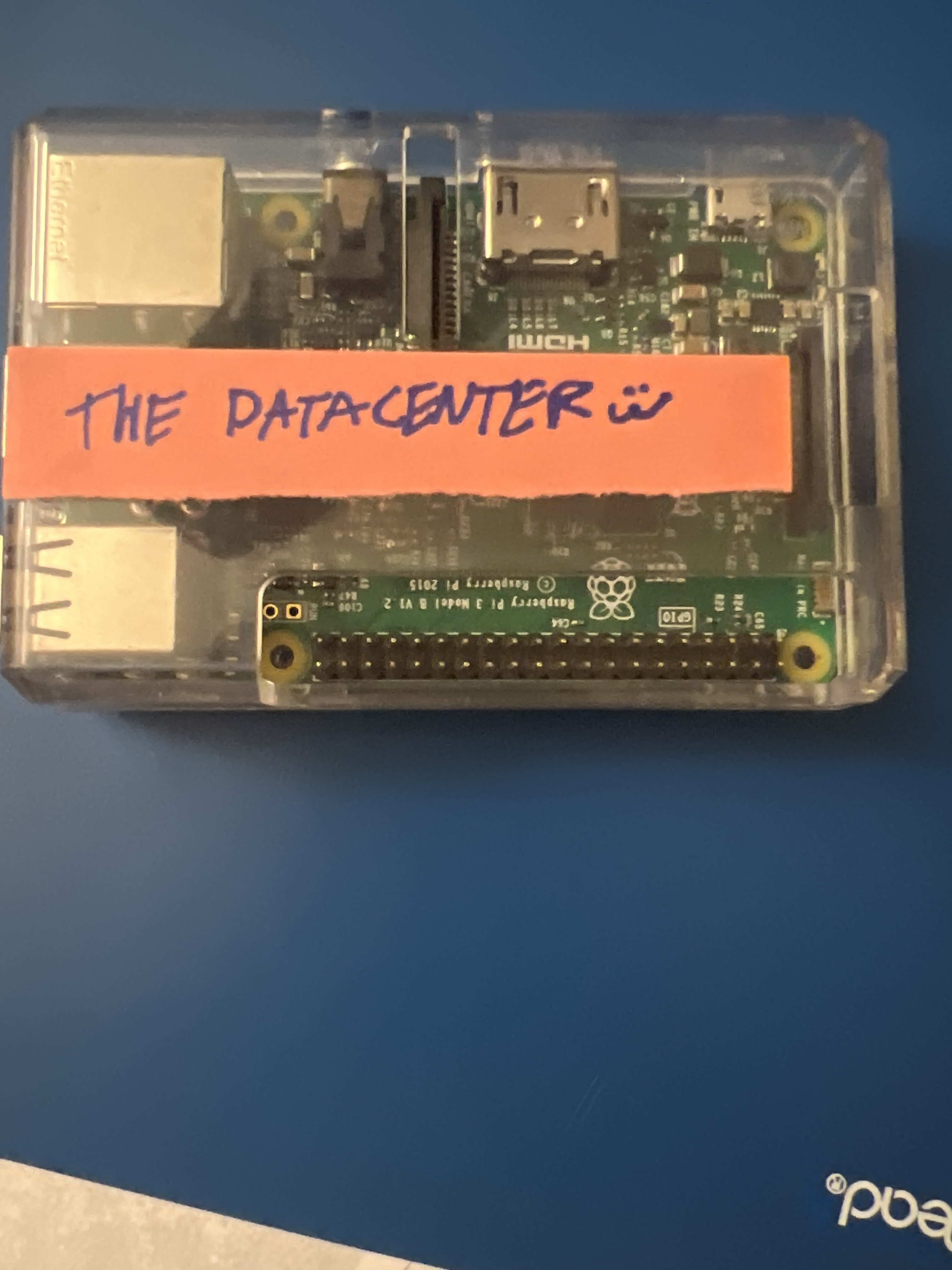 An old Raspberry Pi with a makeshift label that reads 'THE DATACENTER :3'